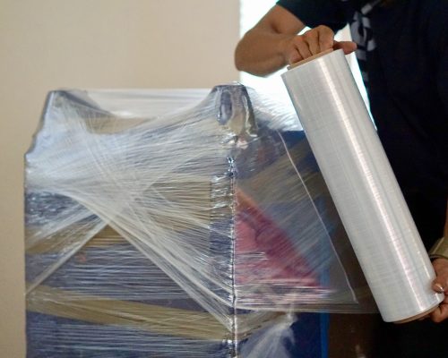 Furniture being wrapped in plastic before moving and storage